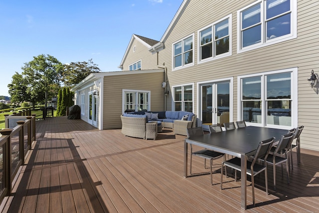 wooden terrace with an outdoor living space and french doors