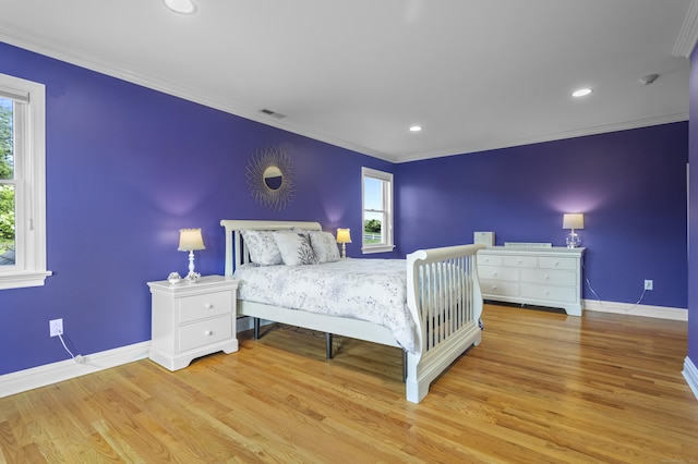 bedroom featuring multiple windows, crown molding, and light hardwood / wood-style floors