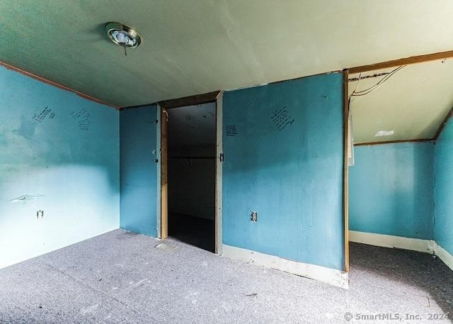 carpeted spare room with lofted ceiling