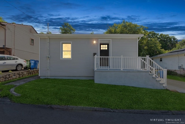 view of front of property featuring covered porch and a lawn