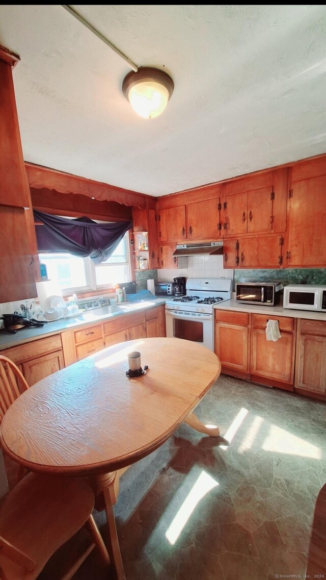 kitchen featuring tasteful backsplash and white appliances