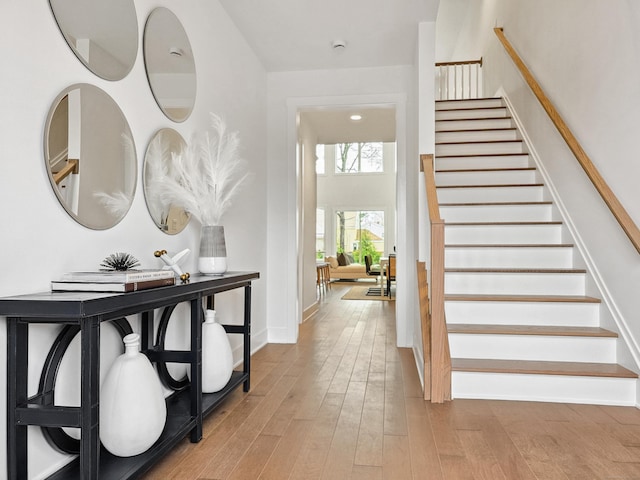 entrance foyer with stairway, baseboards, and wood finished floors