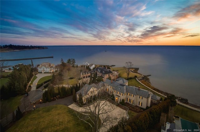 aerial view at dusk featuring a water view