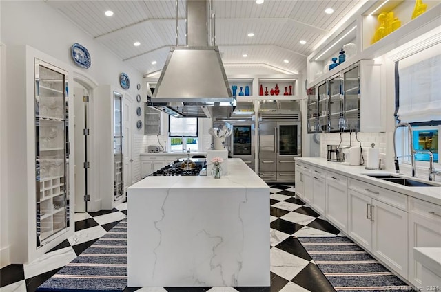 kitchen featuring vaulted ceiling, backsplash, a kitchen island, light tile patterned flooring, and white cabinetry