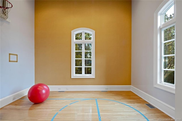 workout area with light hardwood / wood-style flooring and basketball hoop