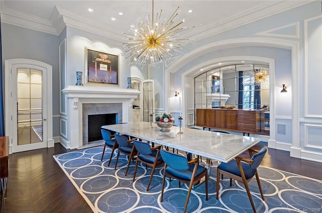 dining area featuring an inviting chandelier, a fireplace, crown molding, and dark hardwood / wood-style flooring