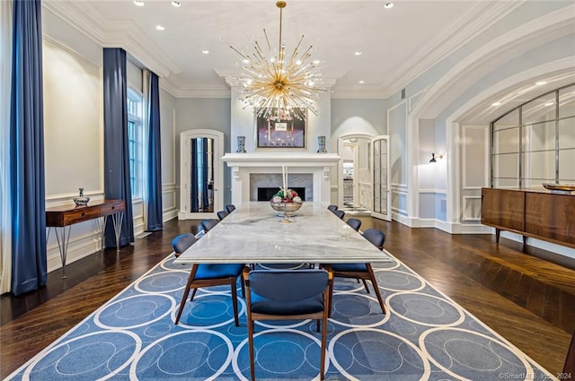 dining room with ornamental molding, a premium fireplace, an inviting chandelier, and dark hardwood / wood-style flooring