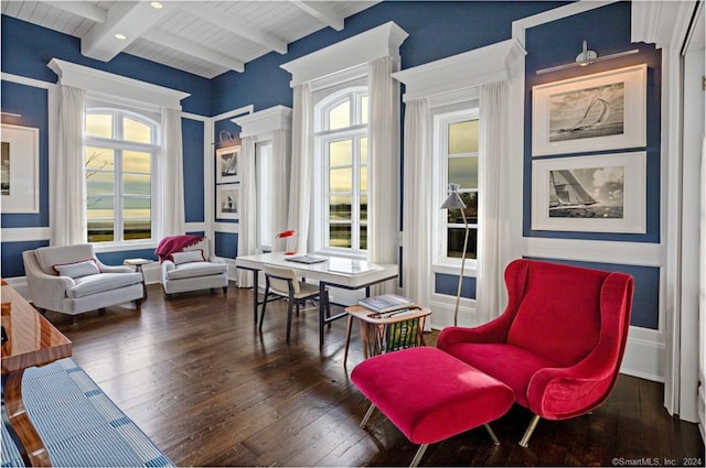 living area featuring beamed ceiling and dark hardwood / wood-style floors