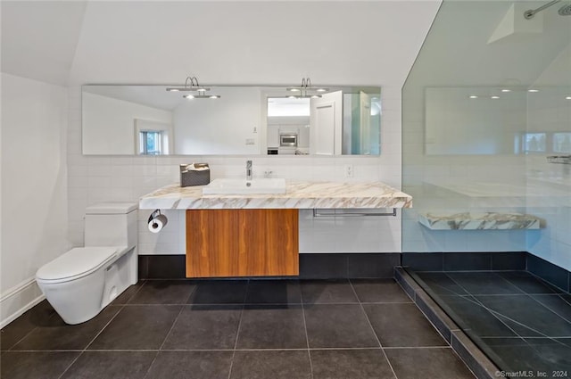 bathroom with vanity, tile patterned flooring, toilet, and tile walls