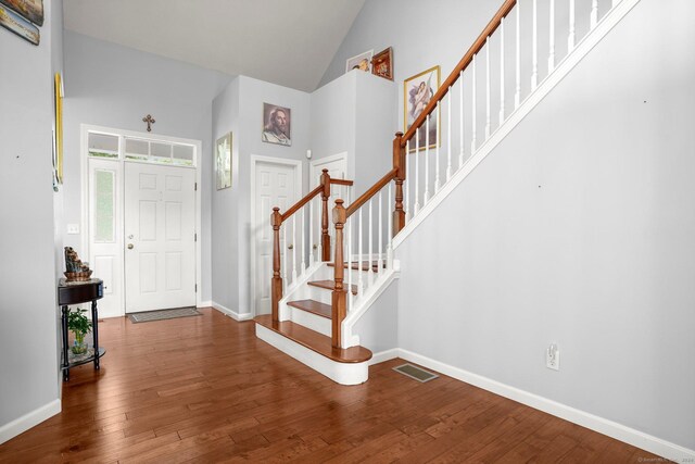 entrance foyer with hardwood / wood-style flooring and high vaulted ceiling