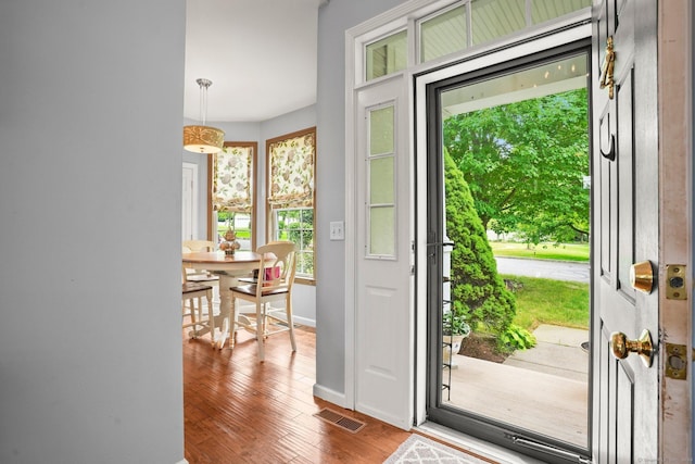 doorway to outside featuring dark wood-style floors, visible vents, and baseboards