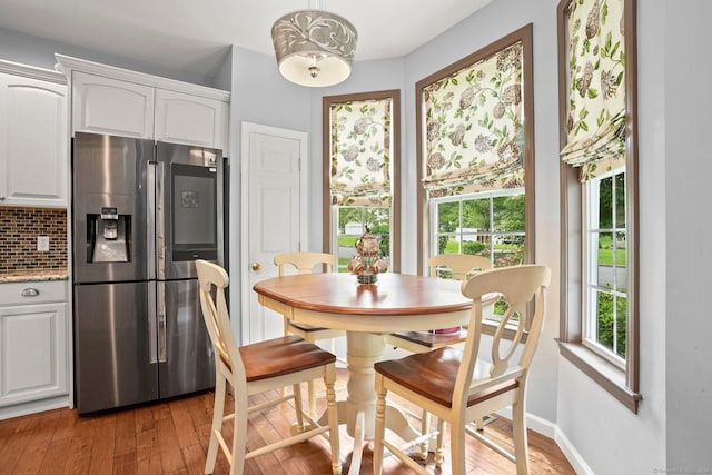 dining space with light wood-style flooring and baseboards