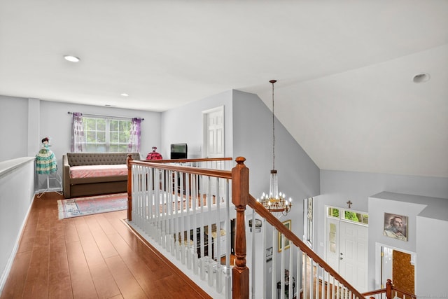 hall with a notable chandelier, recessed lighting, wood-type flooring, an upstairs landing, and baseboards