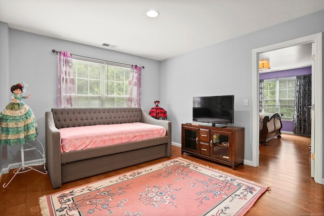 bedroom with visible vents, baseboards, and hardwood / wood-style floors