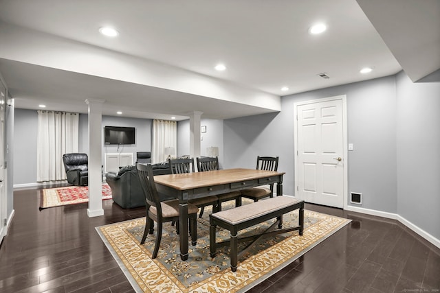 dining room with decorative columns and dark wood-type flooring