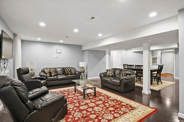 living room featuring dark hardwood / wood-style flooring and decorative columns