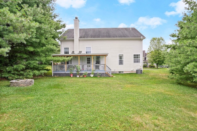 back of property featuring a shingled roof, cooling unit, a yard, and a chimney