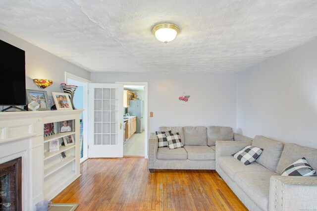 living room with a textured ceiling and hardwood / wood-style flooring