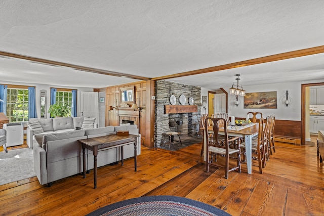 57 NW Corner Rd, Preston, CT 06365 - living room with wood-type flooring, beam ceiling, a fireplace, baseboard heating, and a textured ceiling