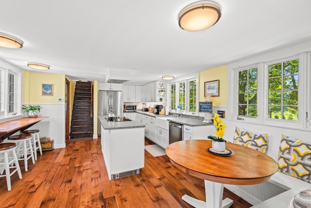 kitchen featuring appliances with stainless steel finishes, hardwood / wood-style floors, white cabinets, and a healthy amount of sunlight