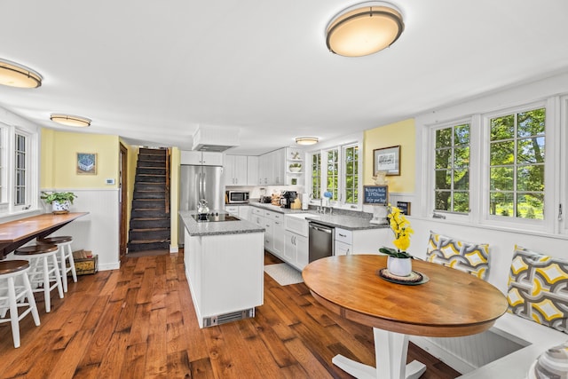57 NW Corner Rd, Preston, CT 06365 - kitchen with a center island, a wainscoted wall, white cabinets, stainless steel appliances, and dark wood-type flooring