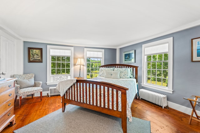 bedroom with radiator and hardwood / wood-style floors