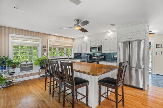 57 NW Corner Rd, Preston, CT 06365 - kitchen with a ceiling fan, a kitchen bar, appliances with stainless steel finishes, light wood-style floors, and butcher block countertops