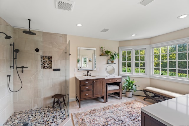 bathroom with tiled shower, vanity, and tile patterned floors