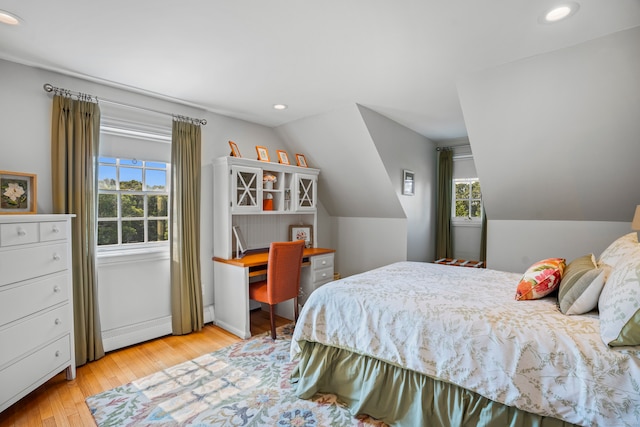 bedroom with multiple windows, baseboard heating, light hardwood / wood-style floors, and lofted ceiling