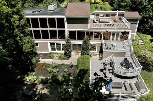 rear view of property with a balcony, stairs, a chimney, and french doors