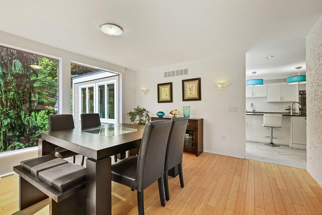 dining space featuring sink and light hardwood / wood-style flooring