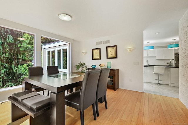 dining room featuring light wood finished floors and visible vents