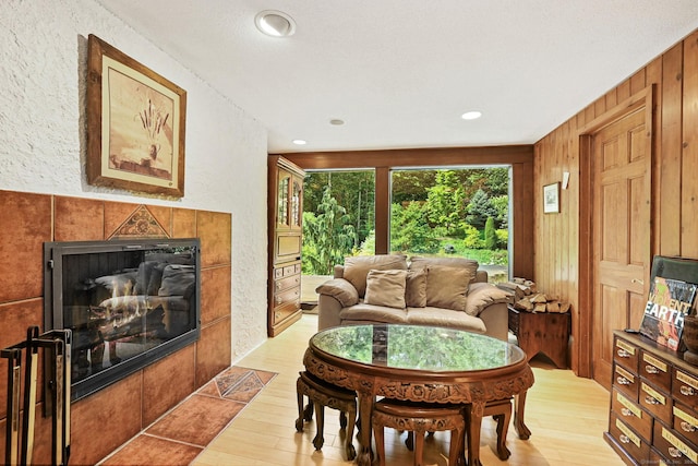 living area featuring light wood-type flooring, a tile fireplace, and recessed lighting