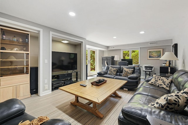 living area featuring recessed lighting, visible vents, and baseboards