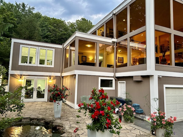 rear view of house with a garage and french doors