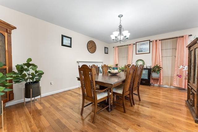 dining space featuring a notable chandelier and light wood-type flooring