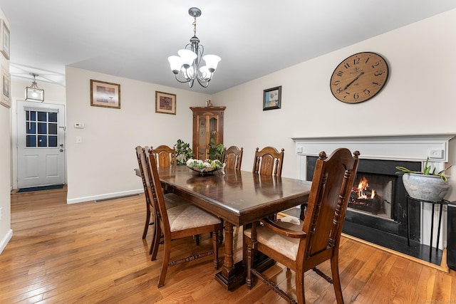 dining space with a chandelier and light hardwood / wood-style flooring