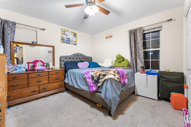 bedroom featuring ceiling fan, refrigerator, and light carpet