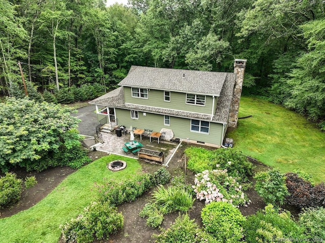 back of house featuring a yard and an outdoor fire pit