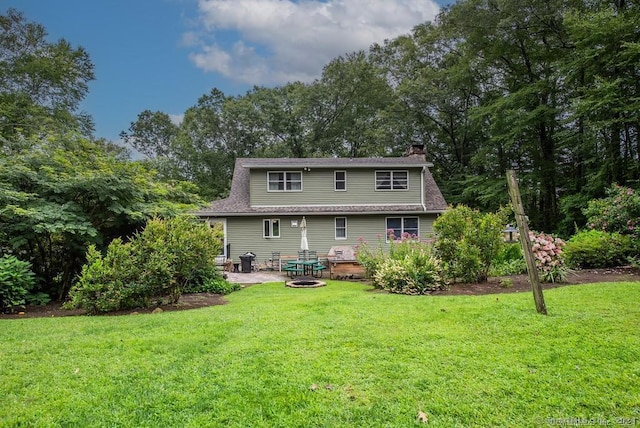 back of house with a lawn and a patio area