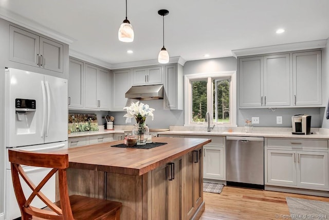 kitchen featuring dishwasher, white fridge with ice dispenser, decorative light fixtures, a kitchen island, and butcher block counters