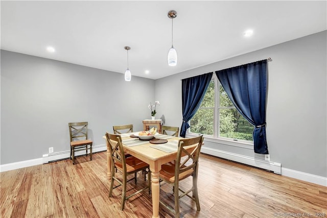 dining area with a baseboard radiator and light hardwood / wood-style flooring