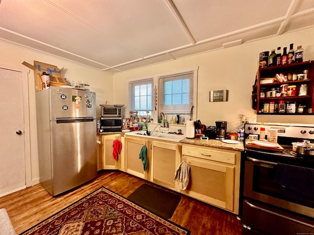 kitchen with sink, dark wood-type flooring, stove, and stainless steel refrigerator