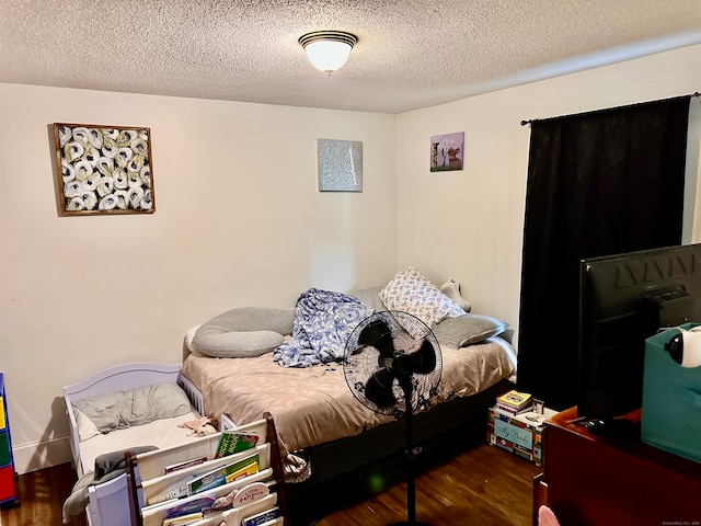 bedroom with dark hardwood / wood-style floors and a textured ceiling