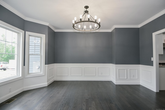 spare room with dark hardwood / wood-style flooring, ornamental molding, and a notable chandelier