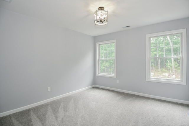 carpeted spare room with a healthy amount of sunlight