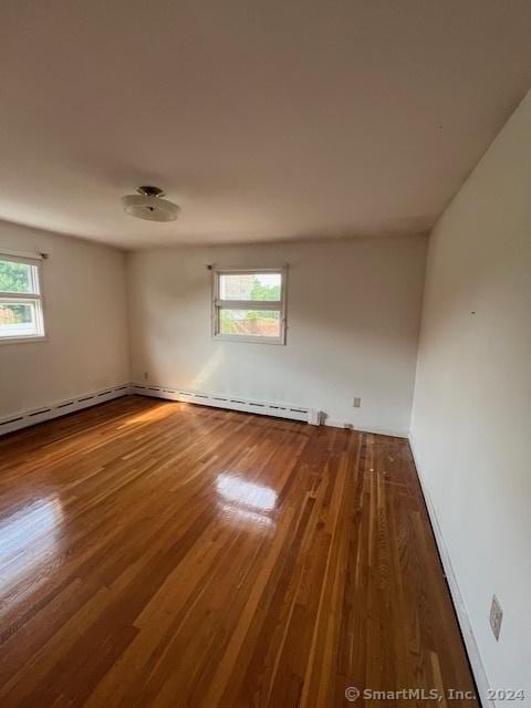 spare room with hardwood / wood-style flooring and a healthy amount of sunlight