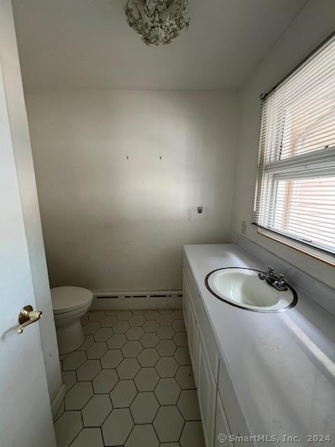 bathroom featuring baseboard heating, vanity, and toilet