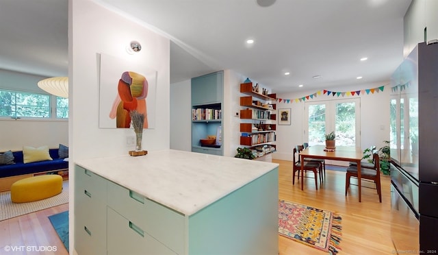 kitchen with french doors, kitchen peninsula, and light hardwood / wood-style floors