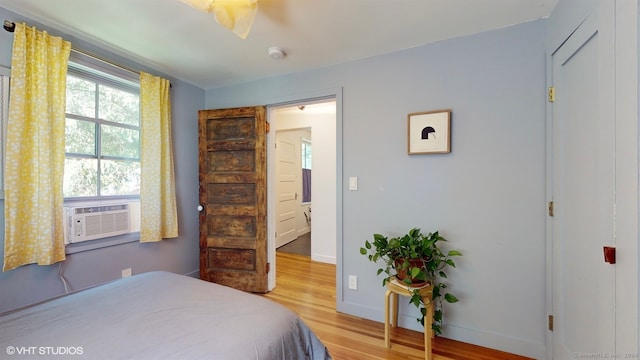 bedroom with cooling unit and hardwood / wood-style floors